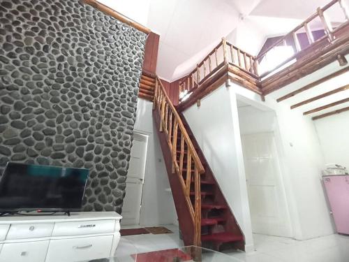 um quarto com uma escada e uma parede com uma televisão em Villa Puncak Little Venice - Kota Bunga em Cikujang