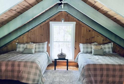 two beds in a attic room with a window at Chalet with a Private Beach in Acadia National Park in Bar Harbor