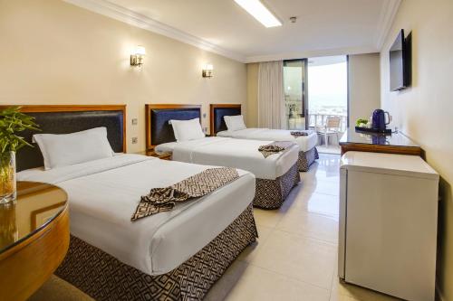 a hotel room with two beds and a television at Dweik Hotel LUXURY 3 in Aqaba