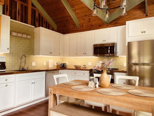a kitchen with white cabinets and a wooden table at Chalet with a Private Beach in Acadia National Park in Bar Harbor