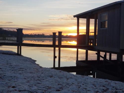 a house on a dock in the water with the sunset at Palazzo Lakeside Hotel in Kissimmee