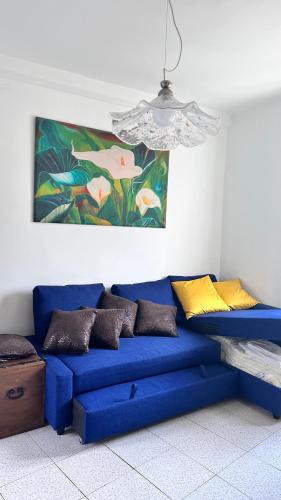 a blue couch in a room with a painting at GolfoParadiso Uscio bombon - PellicceriaSuperior in Uscio