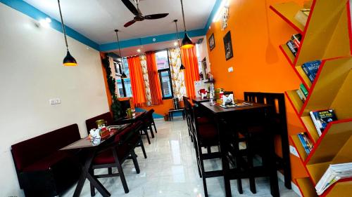 a restaurant with tables and chairs and orange walls at MangalMurti Himalyan Hotel in Almora