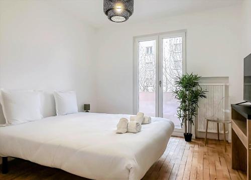 een witte slaapkamer met een groot wit bed en een raam bij Marquis proche du centre ville in Annecy