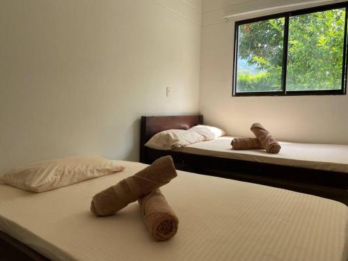 サン・ヘロニモにあるUn paraíso a 30 minutos de Medellín.のベッド2台が備わる客室です。