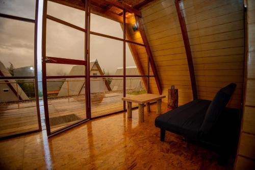 a room with a couch and a table and windows at GLAMPING NAKAMA Cajamarca in Cajamarca
