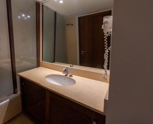 y baño con lavabo y espejo. en Amazing seafront apt in playa den bossa, en Playa d'en Bossa