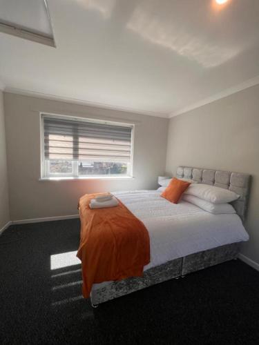 a bedroom with a large bed with an orange blanket at The Coral 66 Guest House Southampton in Southampton