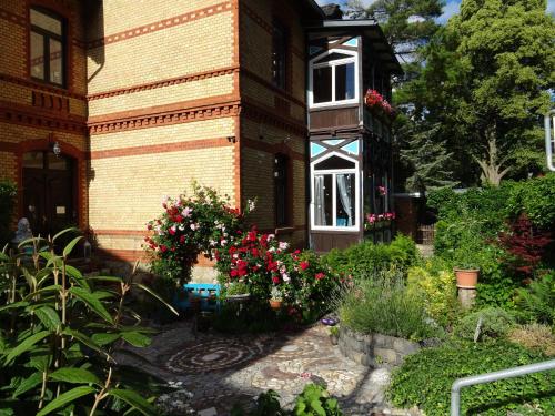 un jardín frente a una casa con flores en " ART DDR" eig Bad dir im Zim, 3 OG, Treppensteigen kein Fruehhstück keine Kueche nur Uebernachtung Parkpl, WIFI, Blankenb, en Blankenburg