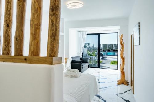 a living room with a table and a chair at Bianco a Nero Mykonos in M&yacute;konos City