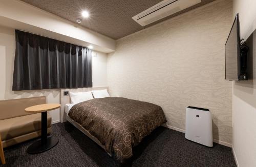 広島市にあるHotel Legitのベッドと椅子付きのホテルルーム