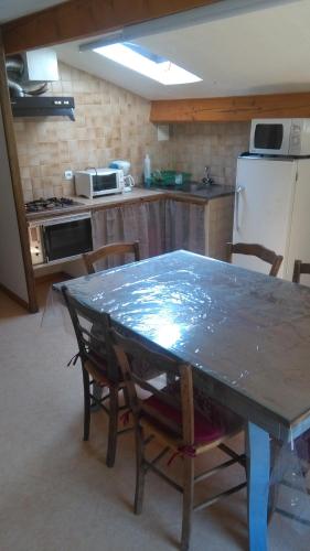 une cuisine avec une table avec des chaises et un réfrigérateur dans l'établissement Mireille, à Castellane