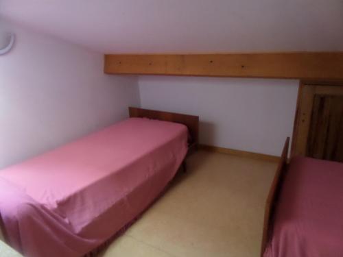 - 2 lits dans une petite chambre avec des draps roses dans l'établissement Mireille, à Castellane