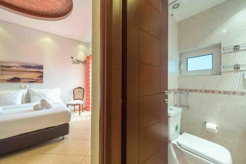 Cette chambre comprend un lit et une salle de bains. dans l'établissement Anavissos 3bdr Seaview Beachhouse with Bbq, à Anavyssos