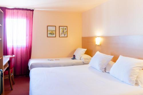 a hotel room with two beds and a window at The Originals City, Hôtel Le Pavillon, Béziers Est in Béziers