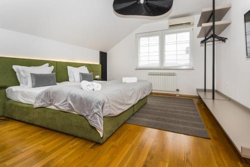 a bedroom with a large bed with a green couch at Art of Living luxury suite three in Sarajevo