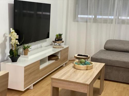 sala de estar con TV de pantalla plana grande en Precioso apartamento en zona de playa, en Almería