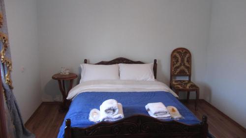 a bedroom with a bed with skulls and towels on it at Blue Guest House in Samtredia
