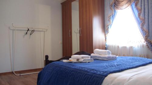 a bedroom with a bed with towels and a window at Blue Guest House in Samtredia