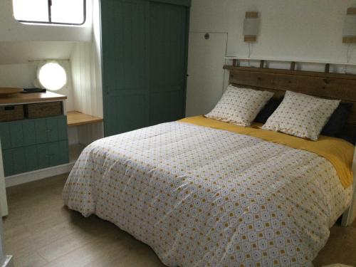 1 dormitorio con 1 cama grande con manta amarilla en Péniche GEMJO en Castelsarrasin