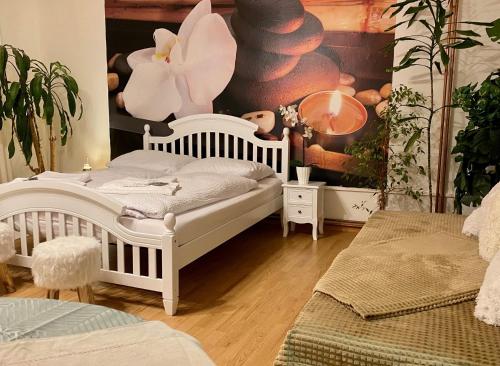 a bedroom with a white bed and a wall with a painting at Beauty-Spa Apartment in Děčín