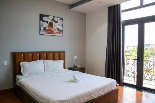 a bedroom with a bed and a large window at HAPPY HOTEL Kien Giang in Ấp Rạch Mẹo