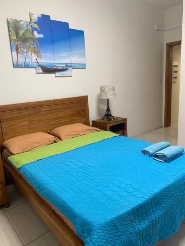 um quarto com uma cama com um edredão azul em Great family-friendly Appartment flic en flac MRU em Flic-en-Flac