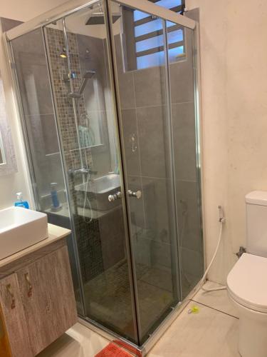 a shower with a glass door in a bathroom at Great family-friendly Appartment flic en flac MRU in Flic-en-Flac