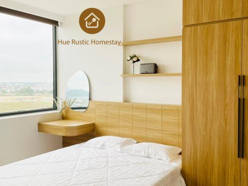 a bedroom with a bed and a desk and a window at Hue Rustic Homestay with Swimming Pool & Gym Room in Thôn Văn Dương