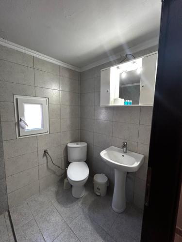 a bathroom with a toilet and a sink at Maison de roche 2 in Nea Kalikratia