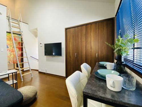 ein Wohnzimmer mit einem Esstisch und weißen Stühlen in der Unterkunft Lucky you! YOTSUYA in Tokio