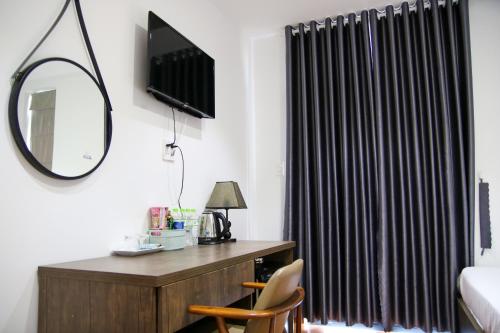 a bedroom with a desk with a mirror and a window at HAPPY HOTEL Tp Rạch Giá, Kiên Giang in Ấp Rạch Mẹo