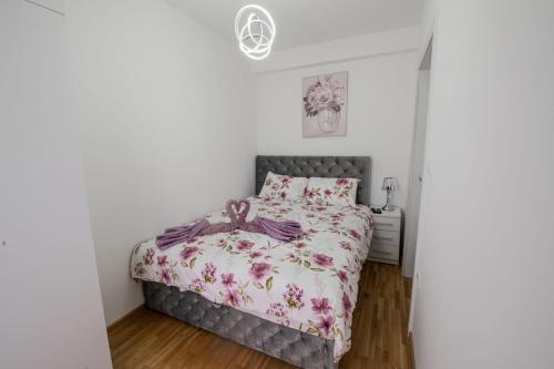 een slaapkamer met een bed met een bloemenbed bij Apartman Neda N in Vrnjačka Banja