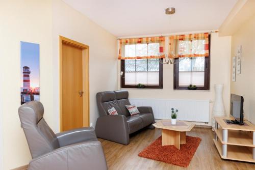 a living room with a couch and a table at Deichhotel Grube in Dorum-Neufeld