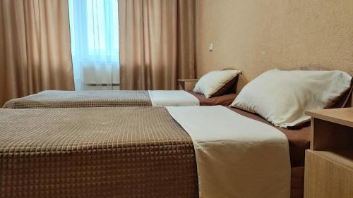 a hotel room with two beds and a window at Василя Стуса 10 City Rooms in Bila Tserkva