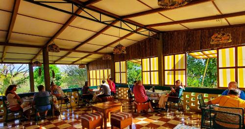 a group of people sitting at tables in a restaurant at El Encanto Garden Hotel in Santa Cruz
