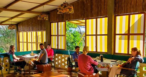 a group of people sitting at tables in a restaurant at El Encanto Garden Hotel in Santa Cruz