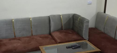 um sofá com um controlo remoto sobre uma mesa em Ikea flat 4 em Hurghada