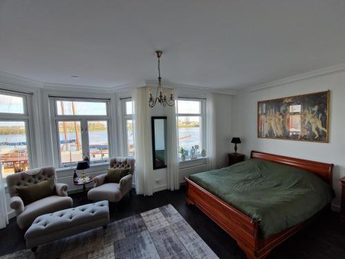 - une chambre avec un lit, des chaises et des fenêtres dans l'établissement 't Hanzehuys, à Kampen