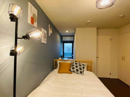 東京的住宿－Lucky you! YOTSUYA，一间卧室配有一张带两盏灯的床。