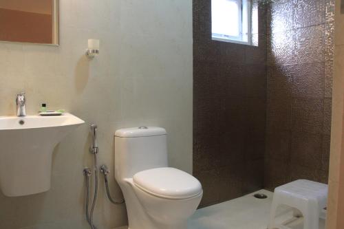 a bathroom with a toilet and a shower and a sink at Two Seas Residence in Ooty