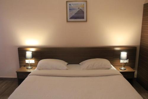a bedroom with a large bed with two lamps on tables at Two Seas Residence in Ooty