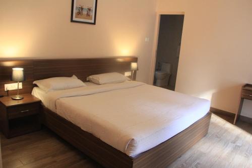 a bedroom with a large bed with a wooden headboard at Two Seas Residence in Ooty