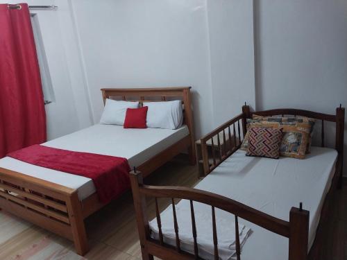 two twin beds in a room with red curtains at 2 spacious bedrooms in Mombasa