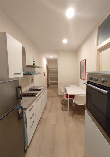 a kitchen with white cabinets and a table in it at Appartamento a due passi dal mare. Civitanova M. in Civitanova Marche