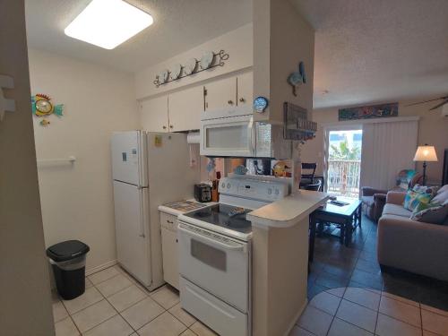 a kitchen with white appliances and a living room at Bay Tree B4 in Port Aransas
