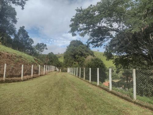 a fence on the side of a dirt road at Pousada Recanto das Hortênsias in Cunha