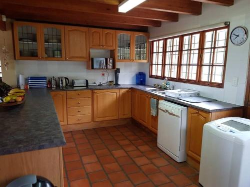 cocina con armarios de madera y lavavajillas blanco en Witteklip self-catering farm, en Kleinmond