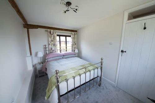 a bedroom with a bed and a window at Countryside cottage with pool in High Halden