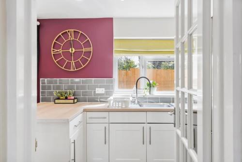 a kitchen with a large clock on the wall at Designer House in Bristol - Hot Tub - Sleeps 10 in Bristol